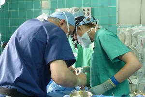 Dr. Fusi and Craig Working Closely Over Patient On Operating Bed